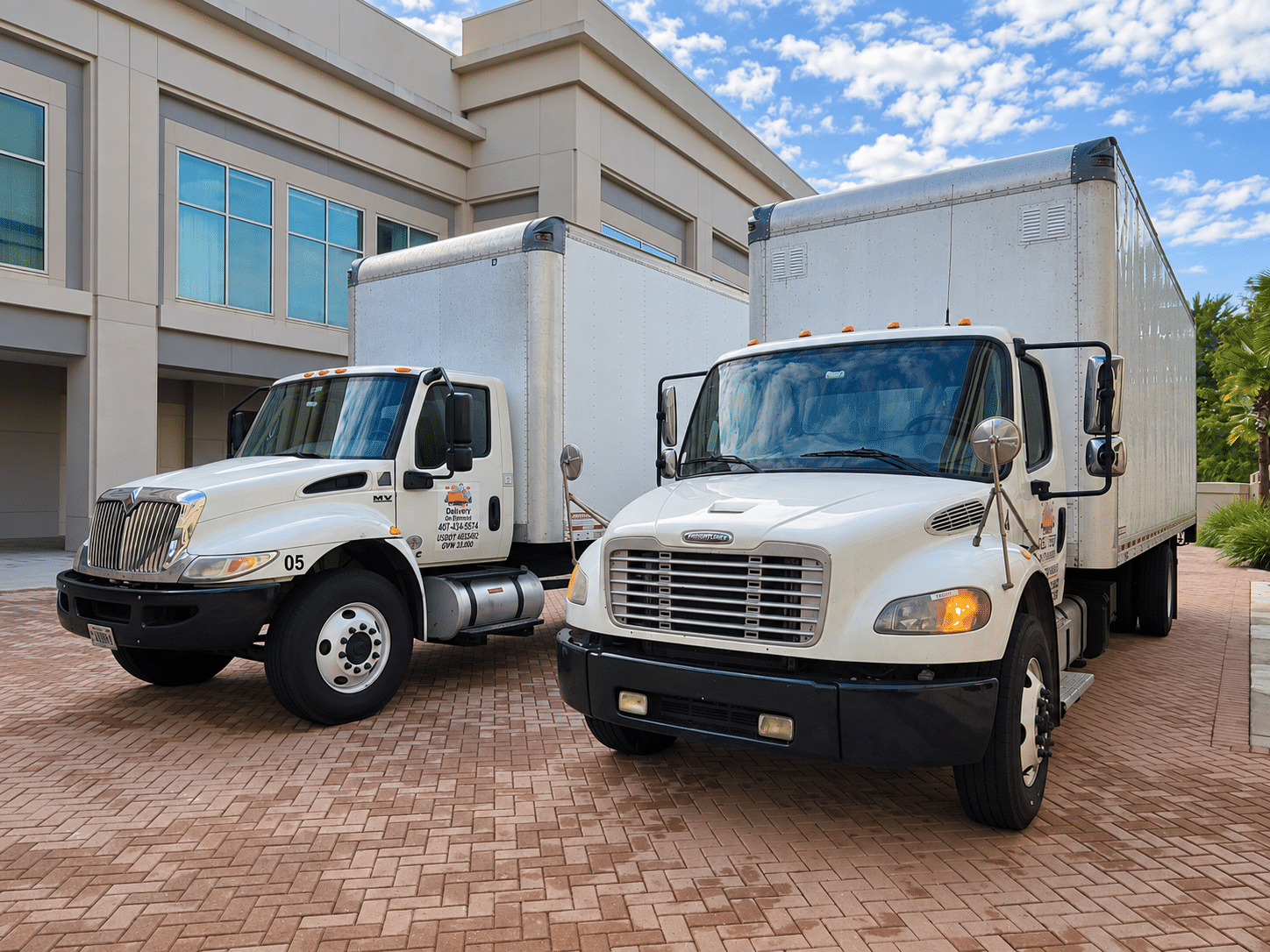 Two Delivery On Demand box trucks at a delivery location